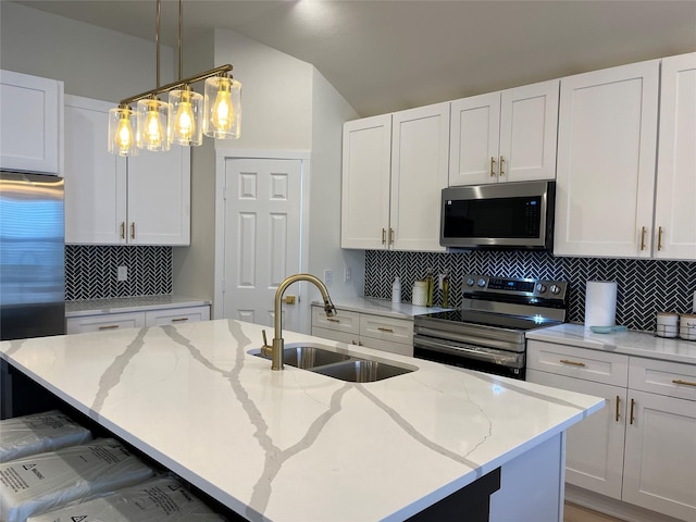 214 E 15th Ave, Corsicana, TX 75110 - kitchen featuring appliances with stainless steel finishes, backsplash, an island with sink, light stone countertops, and white cabinetry