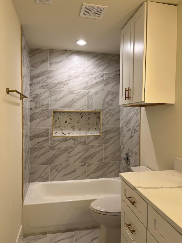 full bathroom with tiled shower / bath combo, vanity, and toilet