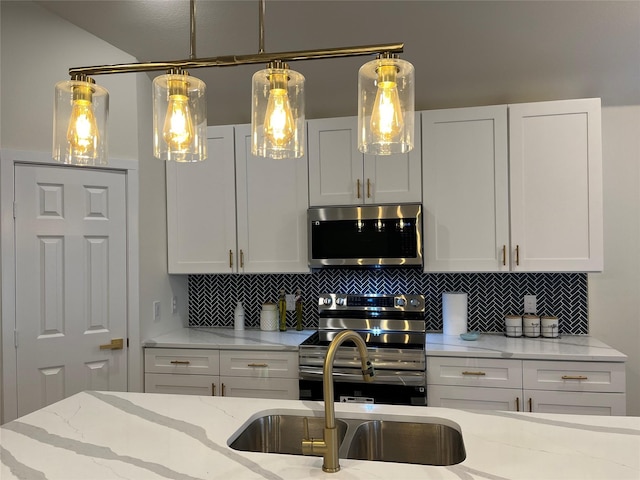 kitchen with tasteful backsplash, appliances with stainless steel finishes, light stone countertops, and white cabinets