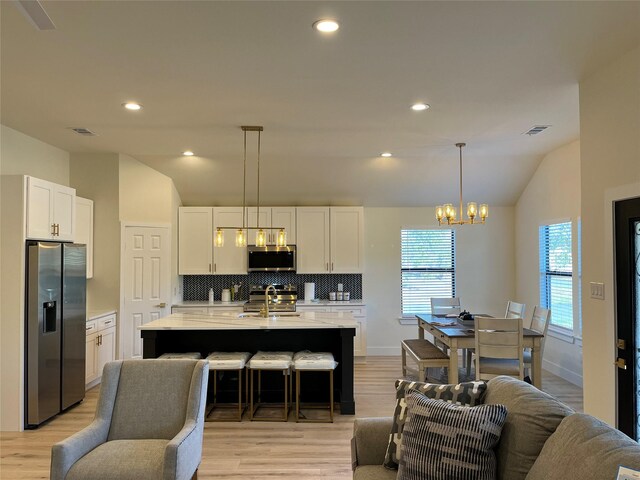 214 E 15th Ave, Corsicana, TX 75110 - kitchen featuring stainless steel appliances, lofted ceiling, open floor plan, backsplash, and light countertops