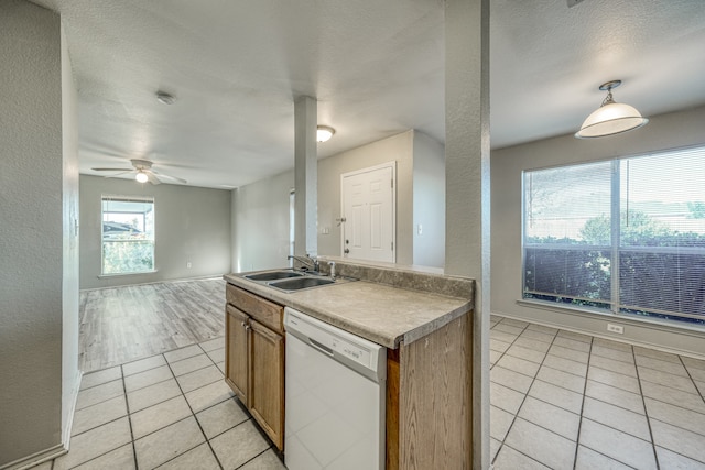 kitchen featuring white dishwasher, plenty of natural light, light tile patterned floors, and a textured ceiling