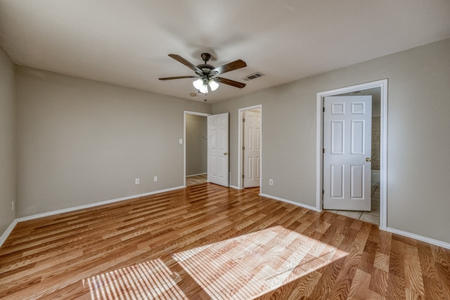 unfurnished bedroom featuring light wood-type flooring, ceiling fan, and connected bathroom