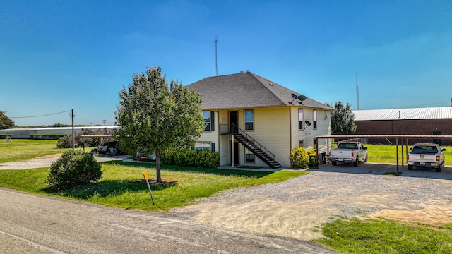 view of front of property featuring a carport and a front lawn