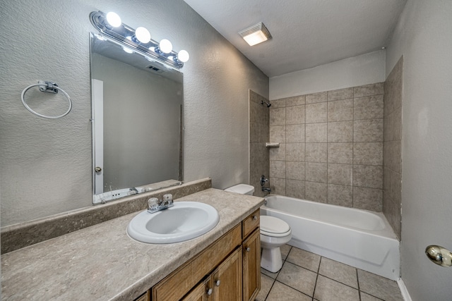 full bathroom featuring tile patterned flooring, a textured ceiling, tiled shower / bath, vanity, and toilet