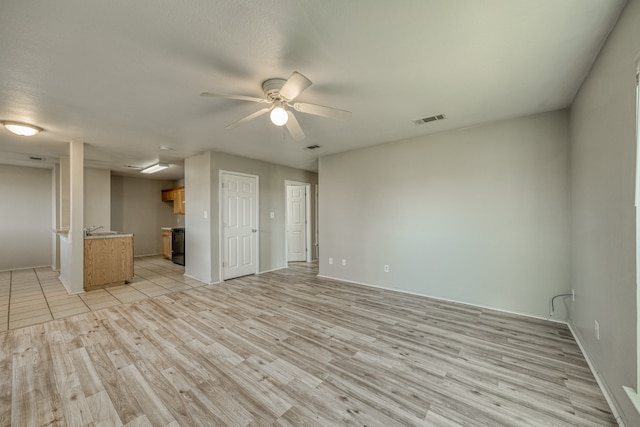 unfurnished living room with ceiling fan and light hardwood / wood-style flooring