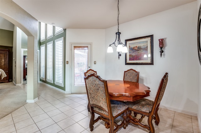 dining space with light tile patterned floors and a chandelier