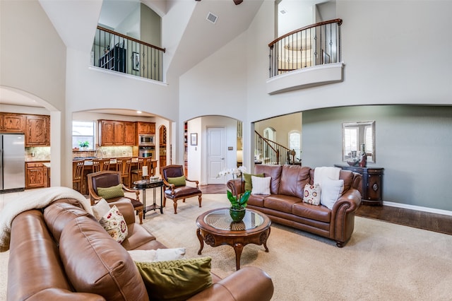 living room featuring high vaulted ceiling, ceiling fan, a textured ceiling, and light hardwood / wood-style floors