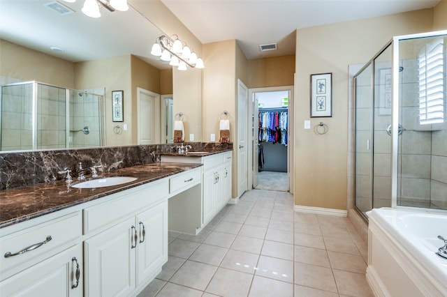 bathroom featuring vanity, a chandelier, tile patterned flooring, and a bathing tub