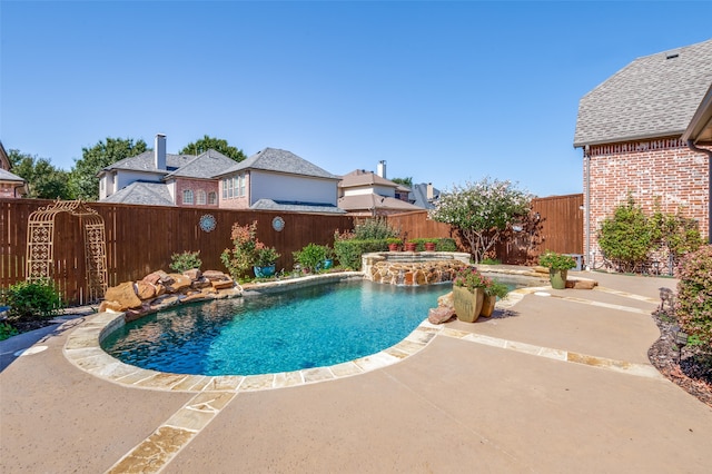 view of swimming pool featuring pool water feature, a patio, and an in ground hot tub