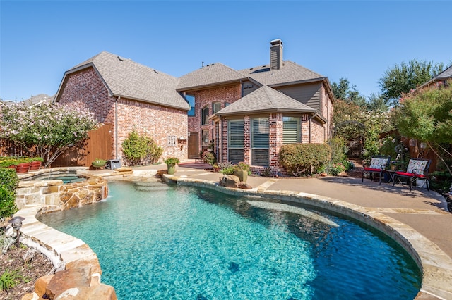 view of swimming pool featuring an in ground hot tub and a patio area