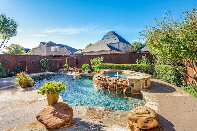 view of swimming pool with pool water feature and an in ground hot tub