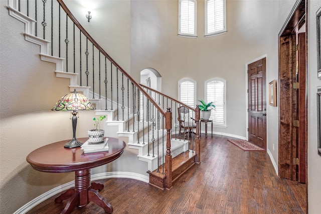 foyer entrance with dark wood-type flooring and a high ceiling