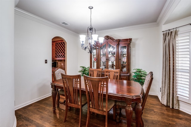 dining area featuring dark hardwood / wood-style flooring, a chandelier, and ornamental molding