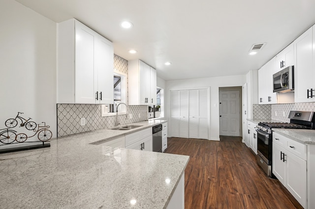 kitchen featuring light stone counters, white cabinetry, dark hardwood / wood-style floors, sink, and stainless steel appliances