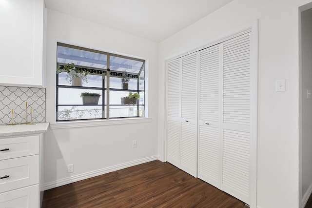 unfurnished bedroom with a closet and dark hardwood / wood-style flooring