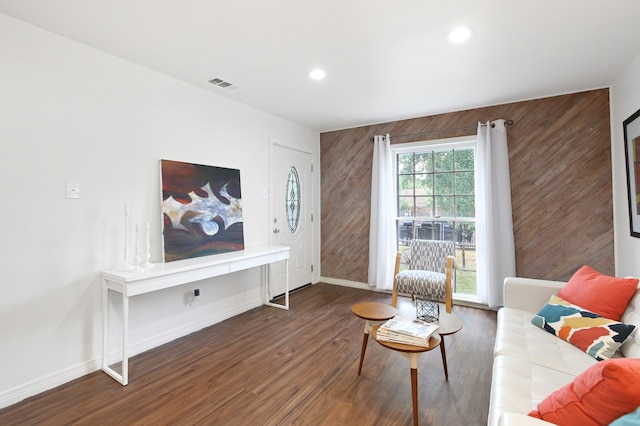 living room featuring dark hardwood / wood-style floors and wooden walls