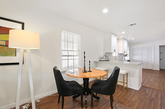 dining room featuring sink and dark hardwood / wood-style flooring