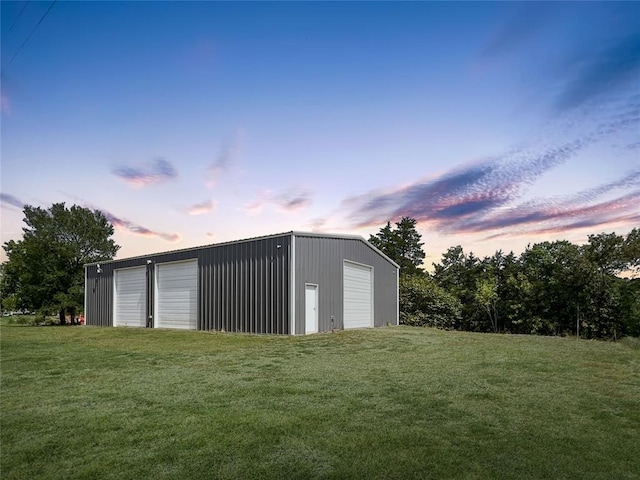 outdoor structure at dusk with a yard and a garage