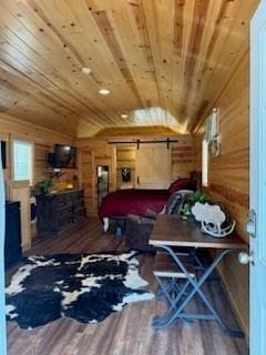 bedroom featuring a barn door, wood ceiling, wooden walls, and dark hardwood / wood-style flooring