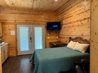 bedroom with hardwood / wood-style floors, wood walls, and wood ceiling