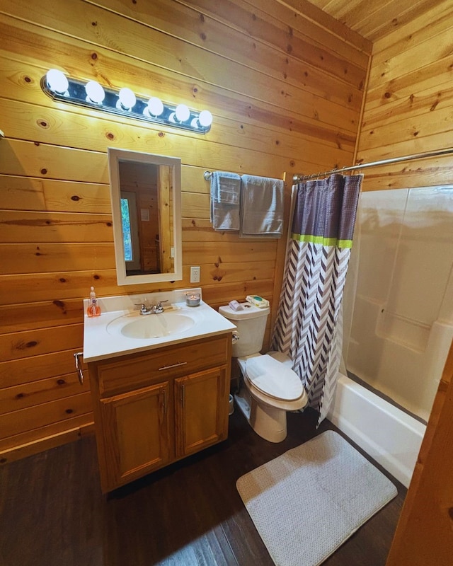 full bathroom with shower / bath combo, wood-type flooring, toilet, wood walls, and vanity