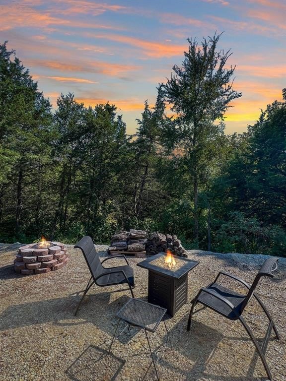 patio terrace at dusk featuring a fire pit