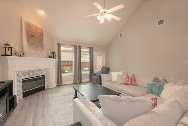 living room with light hardwood / wood-style floors, high vaulted ceiling, and ceiling fan