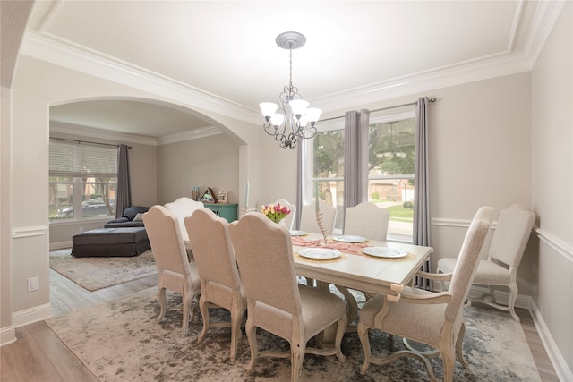 dining area featuring light hardwood / wood-style floors, crown molding, and a chandelier