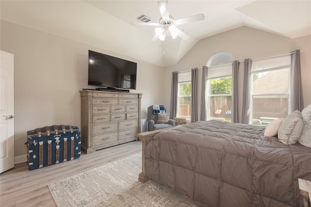 bedroom with ceiling fan, lofted ceiling, and light wood-type flooring