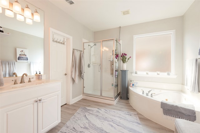 bathroom featuring vanity, hardwood / wood-style floors, and plus walk in shower