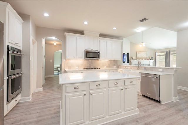 kitchen featuring light hardwood / wood-style flooring, a center island, white cabinetry, appliances with stainless steel finishes, and ceiling fan