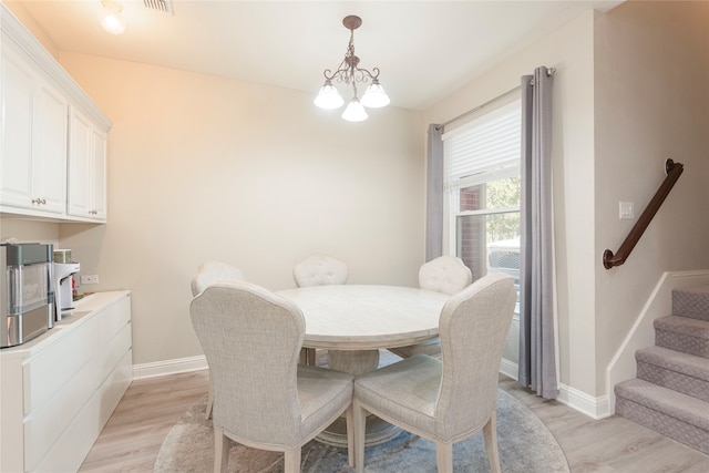 dining area featuring a notable chandelier and light wood-type flooring