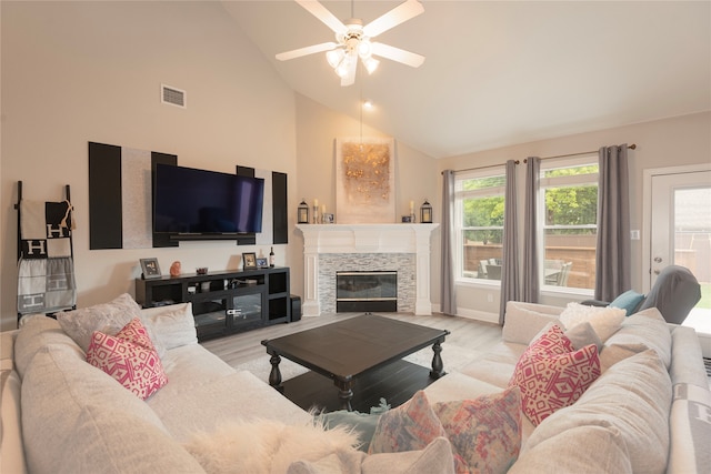 living room with light wood-type flooring, a fireplace, high vaulted ceiling, and ceiling fan