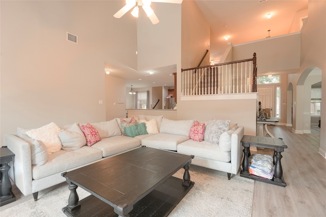 living room featuring light hardwood / wood-style floors, high vaulted ceiling, and ceiling fan