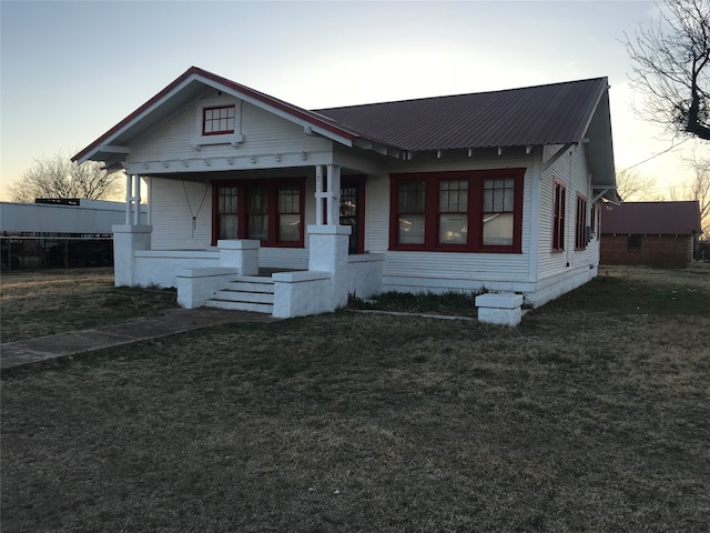 bungalow with a yard and covered porch