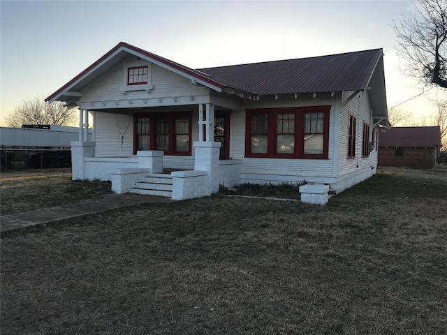 bungalow-style home featuring a lawn and a porch