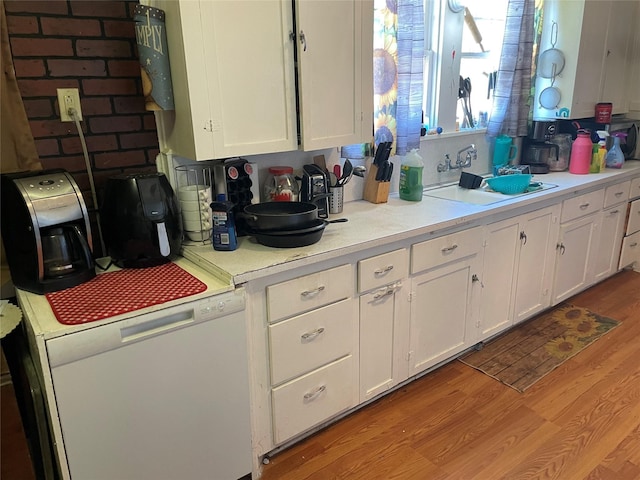 kitchen with sink, white cabinets, white dishwasher, and light hardwood / wood-style floors