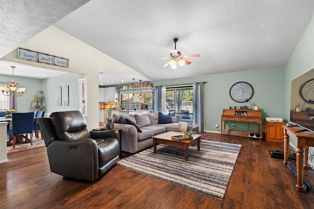 living room featuring ceiling fan with notable chandelier, dark hardwood / wood-style floors, a textured ceiling, and vaulted ceiling