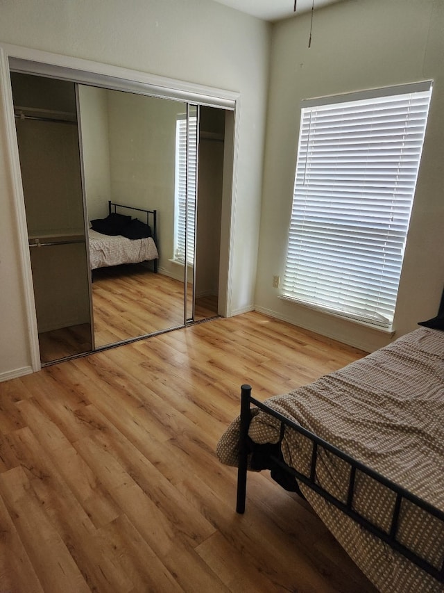 bedroom with light wood-type flooring and a closet