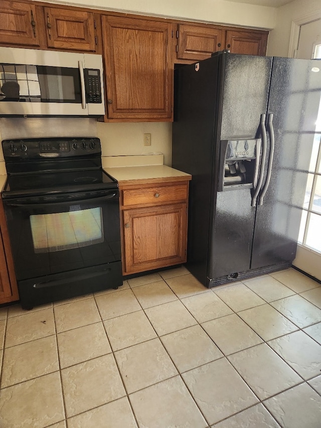 kitchen featuring light tile patterned floors and black appliances