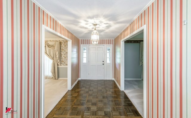 foyer entrance with an inviting chandelier and dark parquet flooring