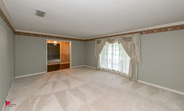 spare room featuring ornamental molding, a textured ceiling, and carpet floors