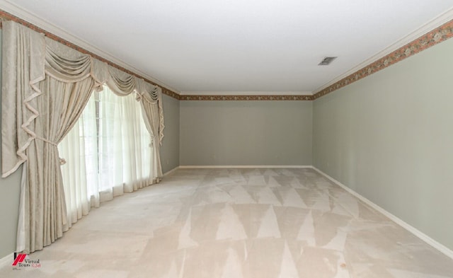 empty room featuring ornamental molding and carpet