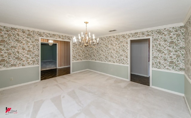 spare room featuring ornamental molding, a notable chandelier, and carpet flooring