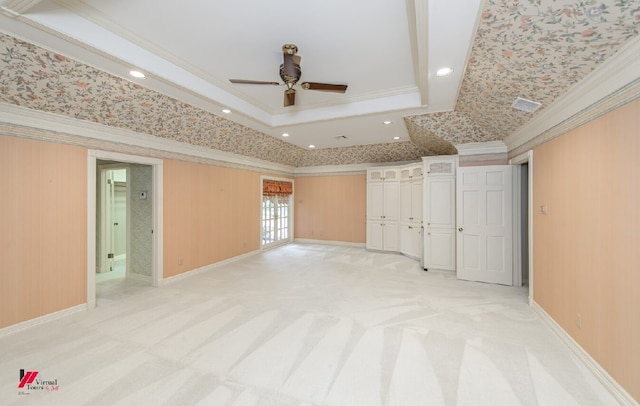 unfurnished bedroom with a raised ceiling, ornamental molding, ceiling fan, and light colored carpet