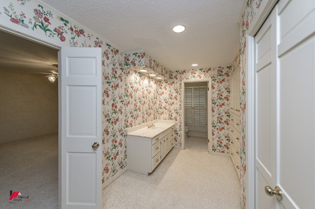 bathroom featuring a textured ceiling, vanity, and ceiling fan