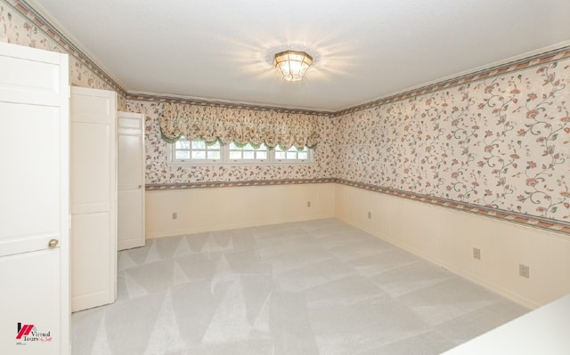 carpeted spare room with crown molding