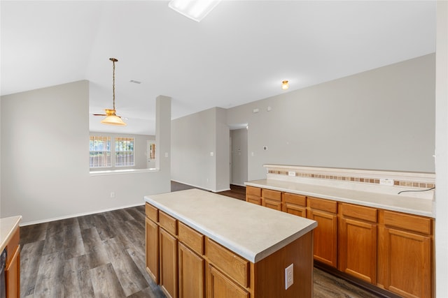 kitchen featuring hanging light fixtures, a kitchen island, dark hardwood / wood-style flooring, and vaulted ceiling