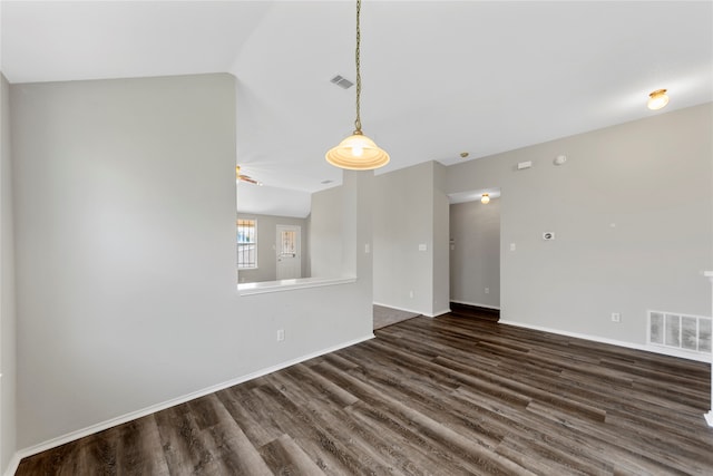 empty room featuring dark wood-type flooring and vaulted ceiling