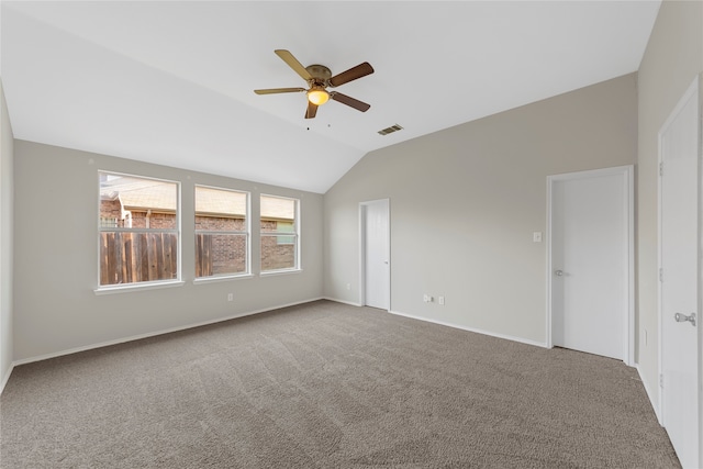 spare room with ceiling fan, vaulted ceiling, and carpet